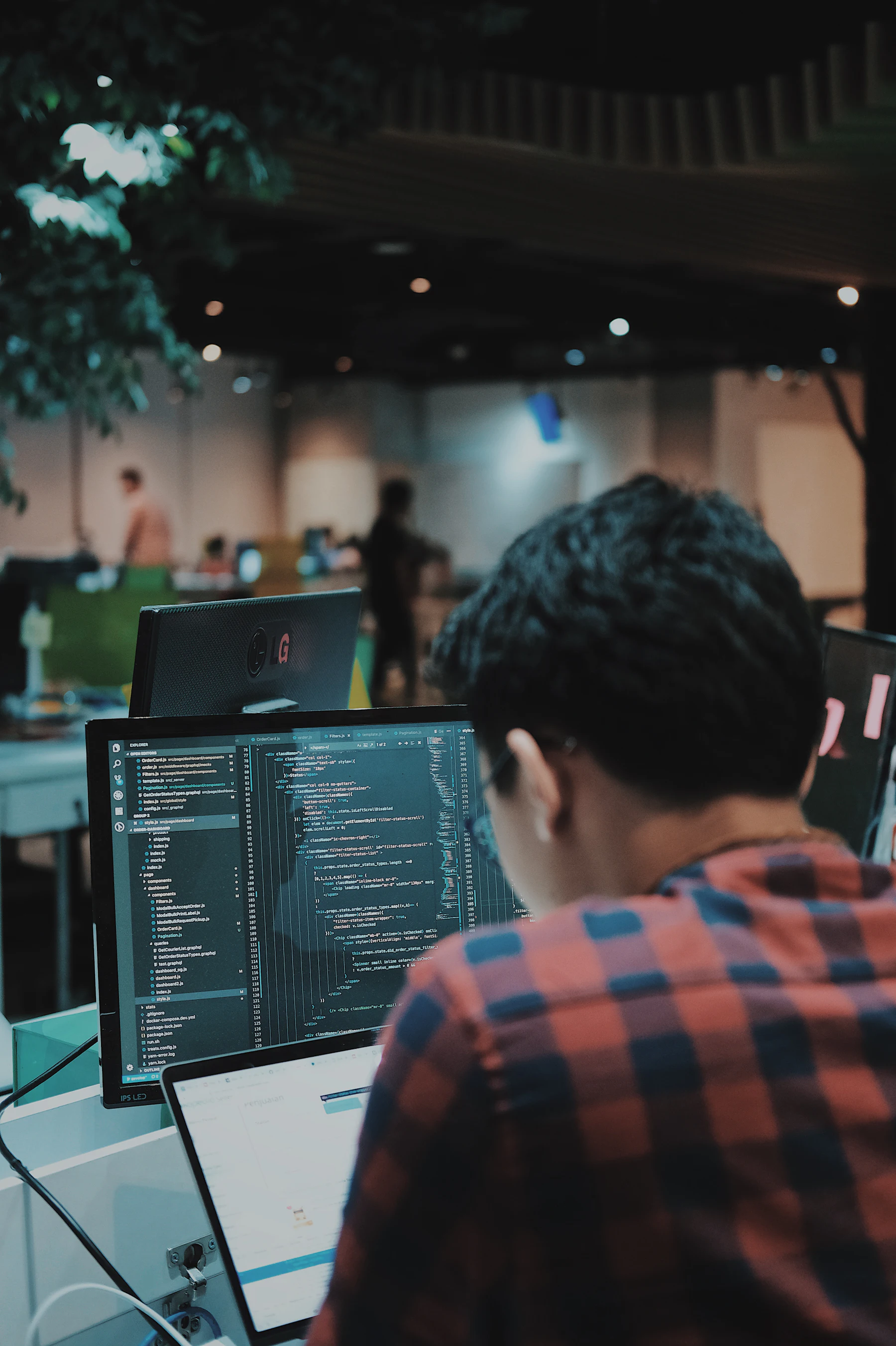 A builder at a desk with code on screen